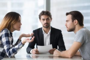 Recently divorced couple arguing over lottery winnings with lawyer present holding paperwork