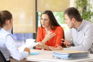 divorced couple discussing student loan debt with a lawyer