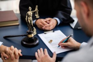 Attorney and client reviewing divorce paperwork with rings and gavel—consultation on defamation in divorce.