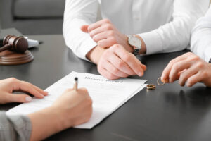 Couple reviewing and signing divorce papers during a contested or uncontested divorce in Raleigh, NC.